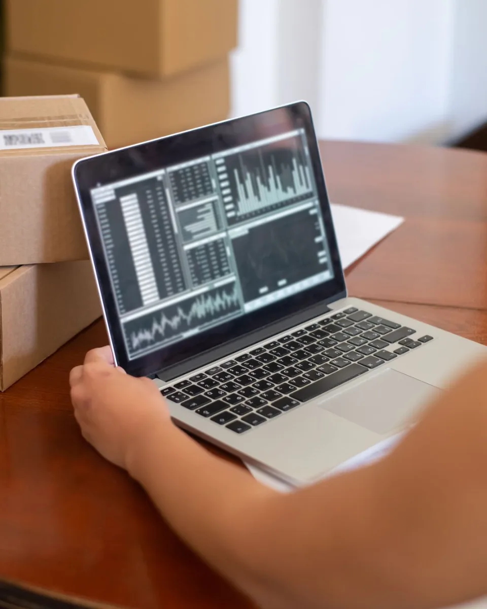 Empreendedor de costas acompanhando números no notebook em seu negócio